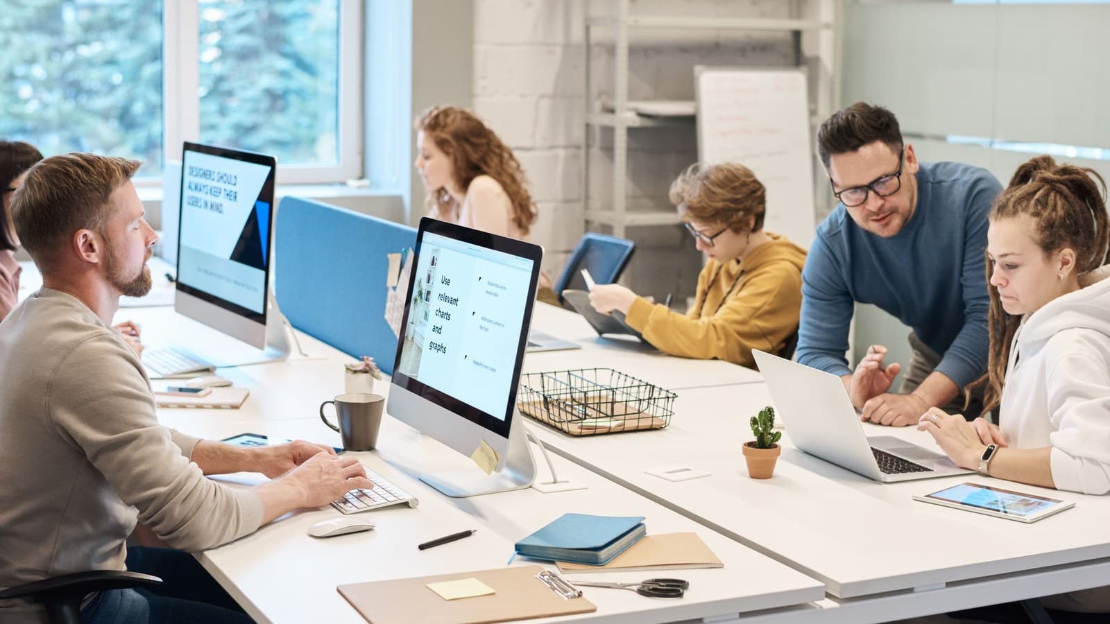 A team collaborates around computers in a bright open office